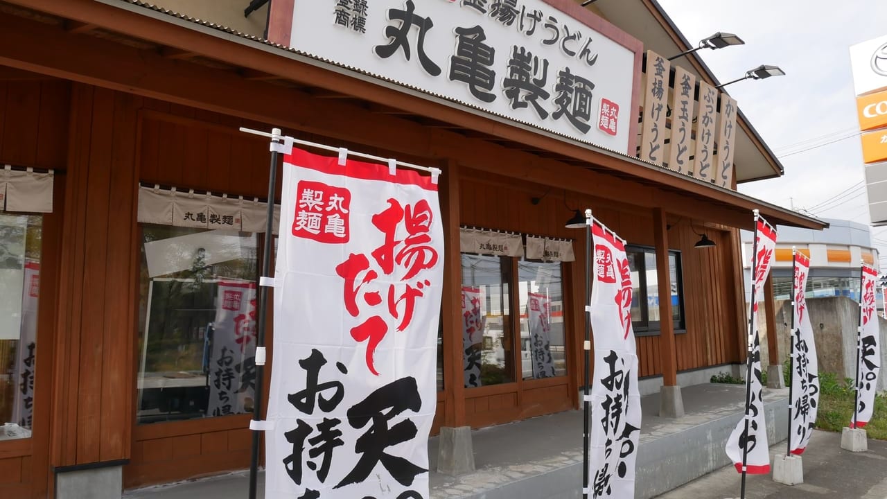 丸亀製麺狭山の外観と、天ぷらのテイクアウトキャンペーンを案内するのぼり