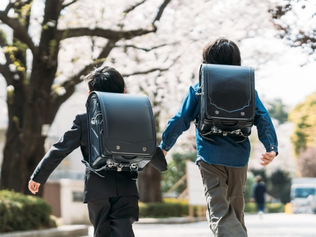 ランドセルを背負って登校する2人の小学生