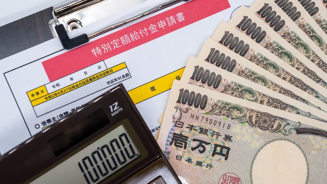 特別定額給付金の申請書類と1万円札と電卓