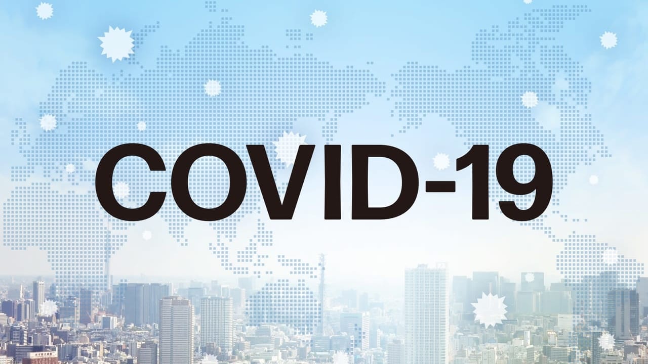 「COVID-19」という文字と都会のビル群