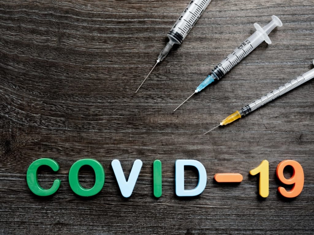「COVID-19」の文字と3本の注射器