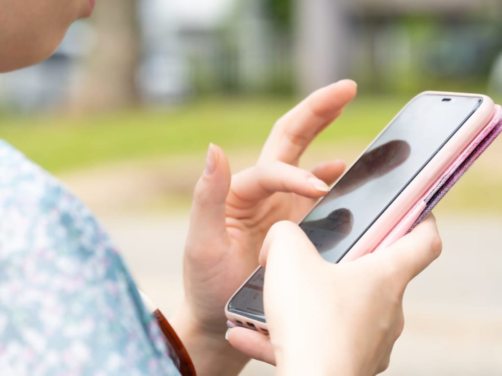 スマートフォンを操作する女性の手