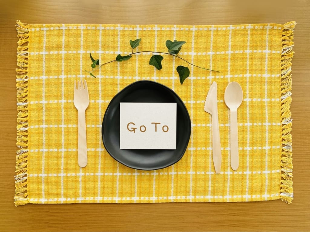 「Go To」と書かれたメモが置かれた黒い皿とランチョンマット