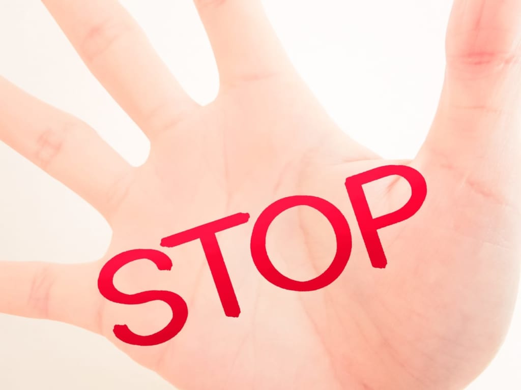 赤く「STOP」と書かれた人の手