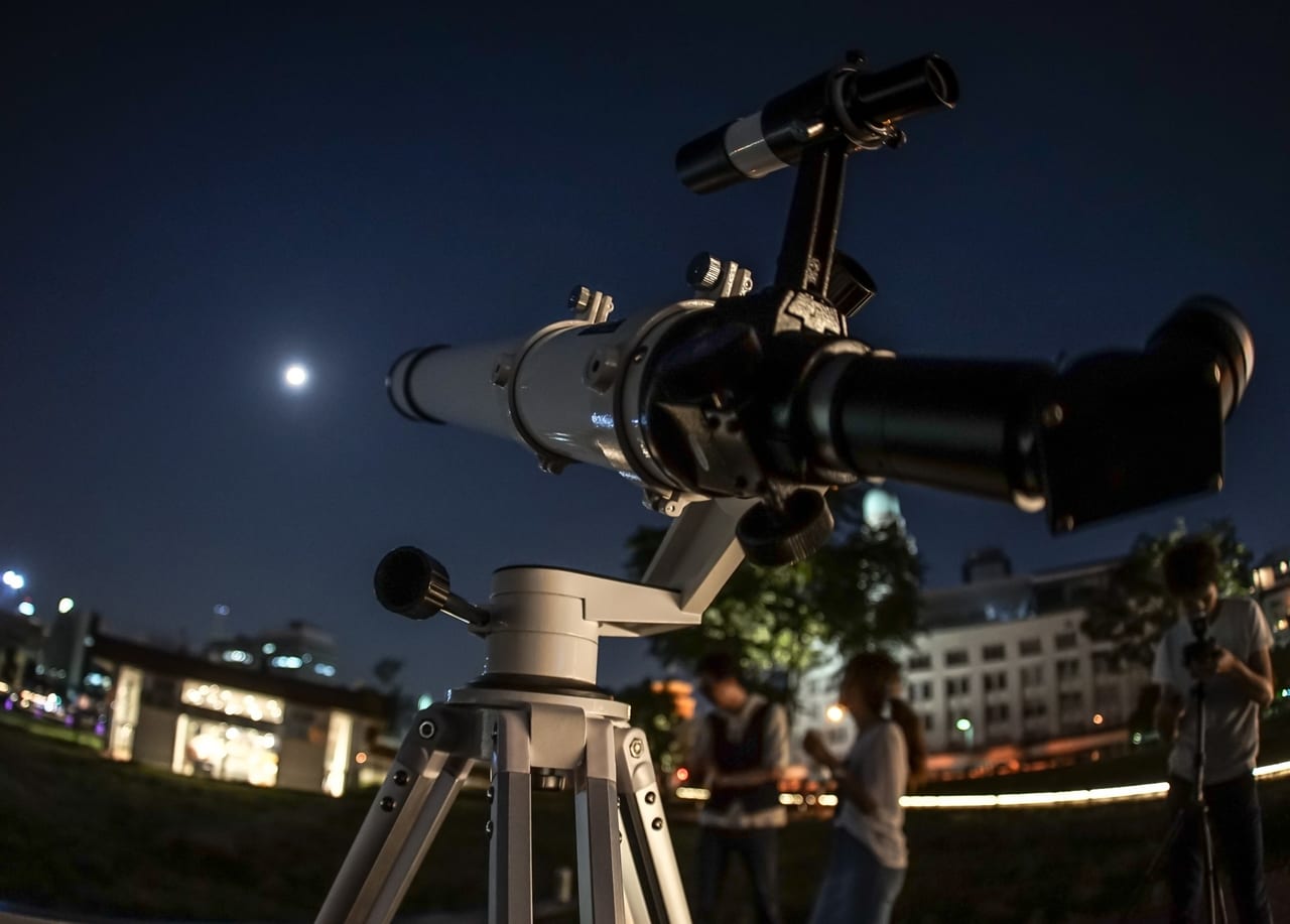 天体望遠鏡で夜空を観測する人たち