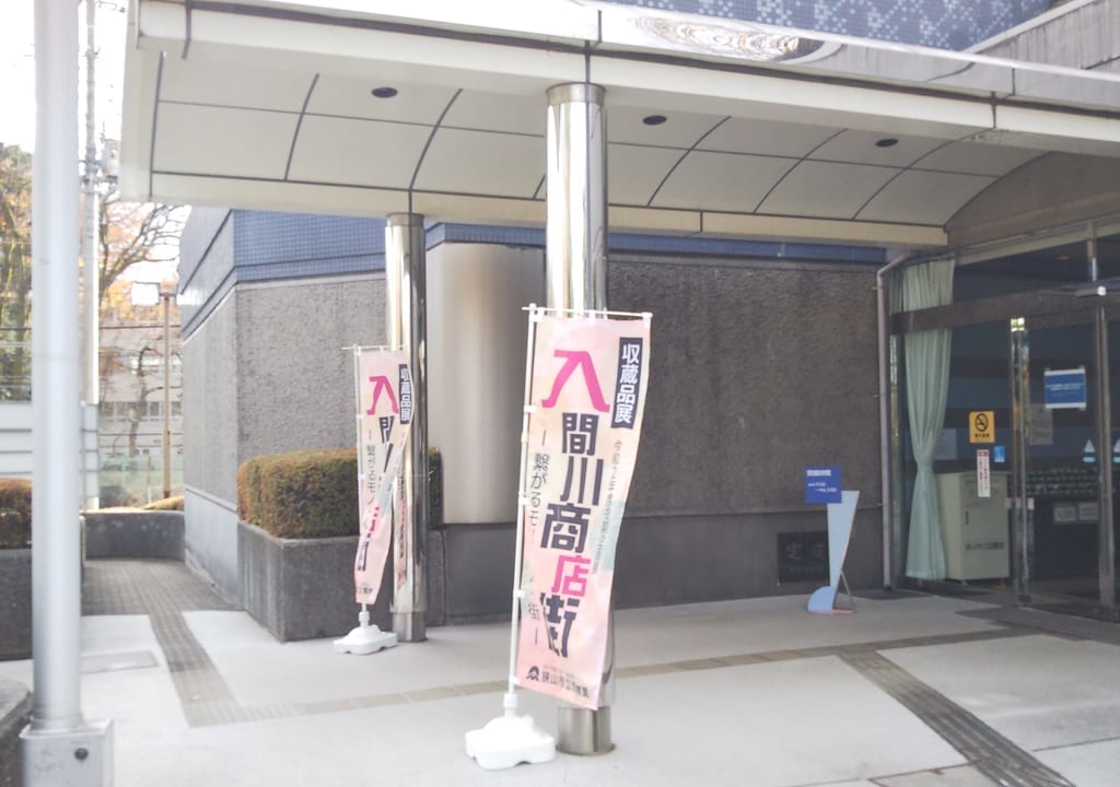 「入間川商店街―繋がるモノ・人・街―」ののぼりがはためく狭山市立博物館の入り口
