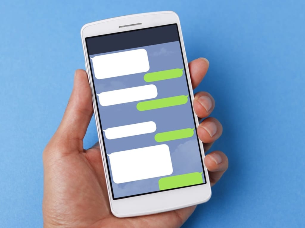 LINEの画面が表示されたスマホを持つ人の手