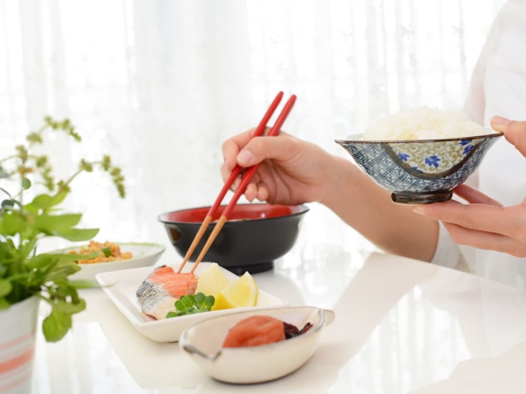 和朝食と箸を持つ女性の手