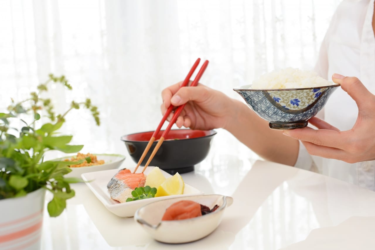 和朝食と箸を持つ女性の手