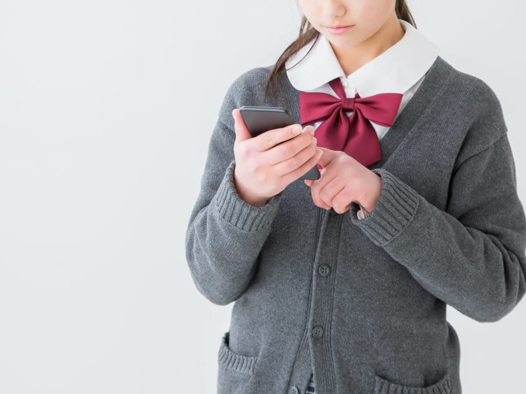 スマートフォンを操作する制服姿の女の子