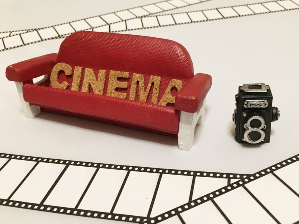 「CINEMA」と書かれたソファーと映像フィルム