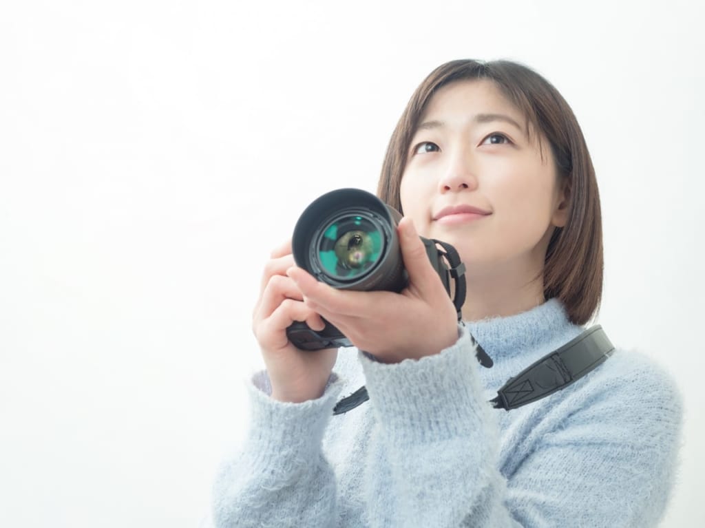 カメラを構える若い女性